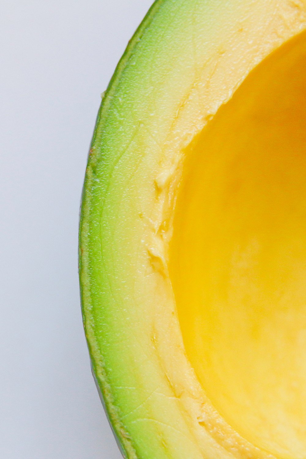 Extreme close-up of a halved avocado showing its cross-section and pit cavity.